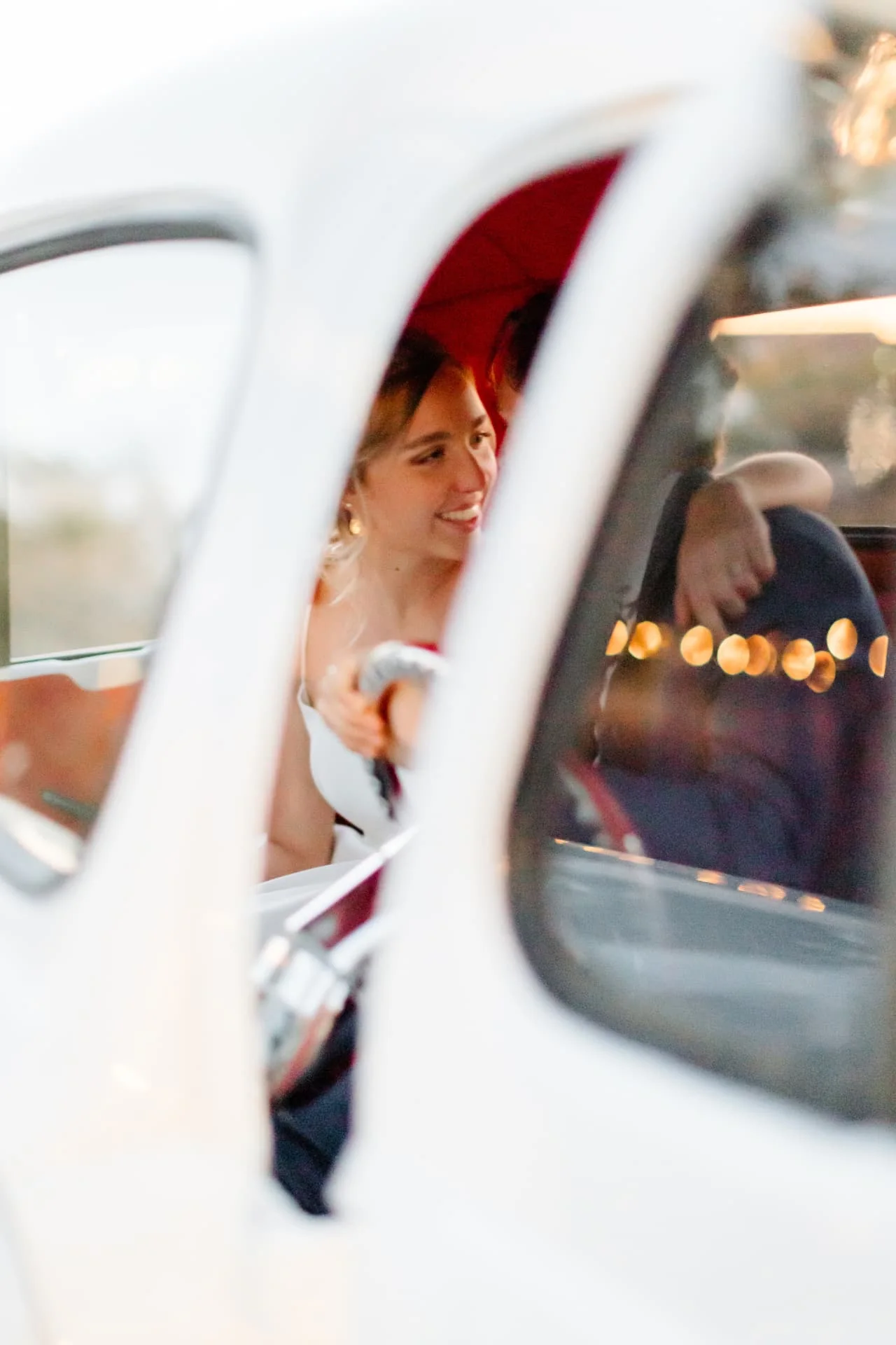 Bride laughing in the driver's seat of a vintage truck with red leather interior — candid Scottsdale Arizona wedding photo