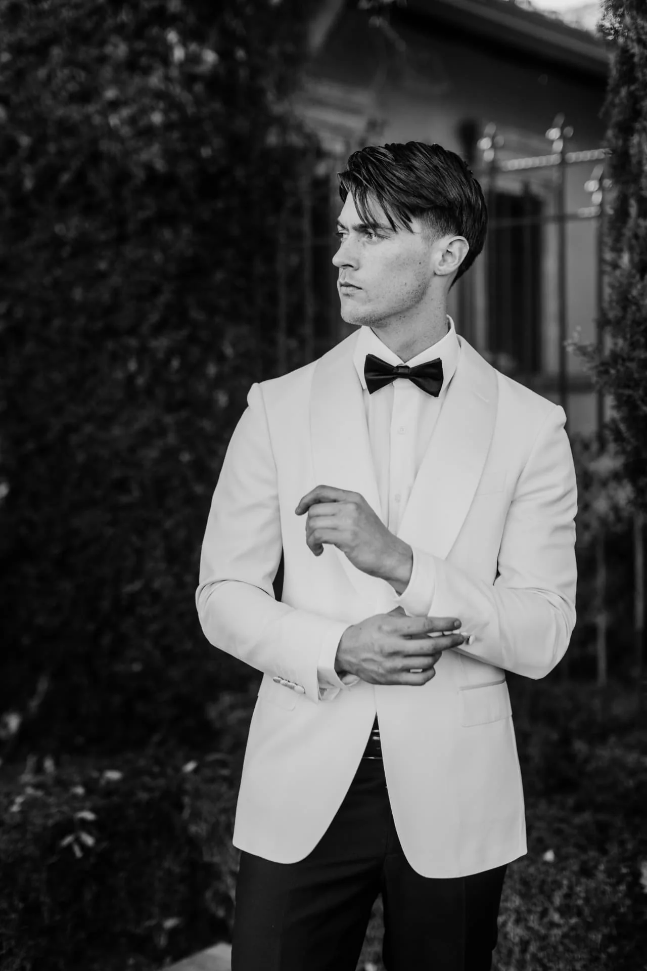 Groom in a cream tuxedo with black bow tie in black and white — editorial Arizona wedding portrait