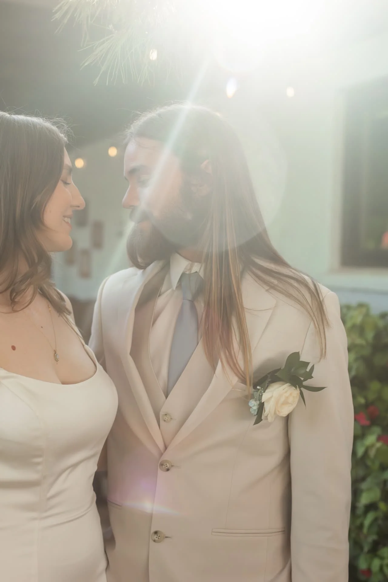 Bride and groom face to face backlit by warm sun flare — soft, dreamy Arizona wedding portrait